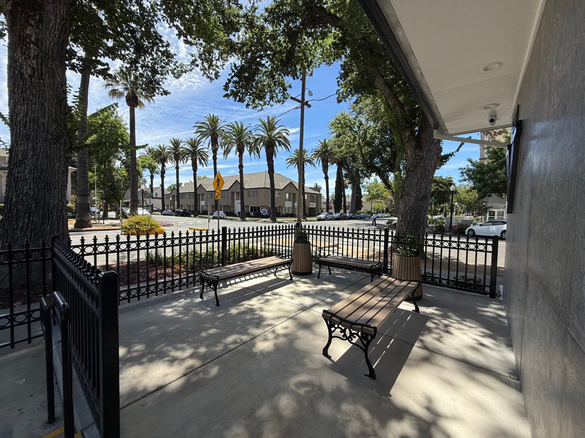 Shaded patio entrance to the dental office with benches and trees